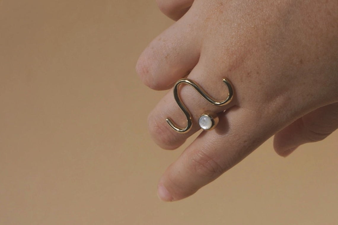 ring with brass squiggle and shiny white stone 