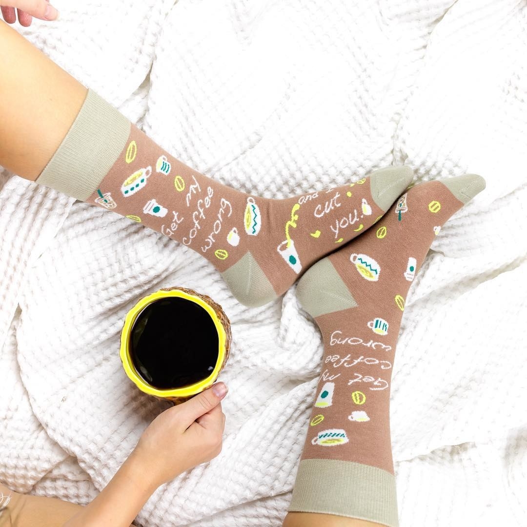 a model wearing the socks which say &quot;get my coffee wrong and I cut you&quot;