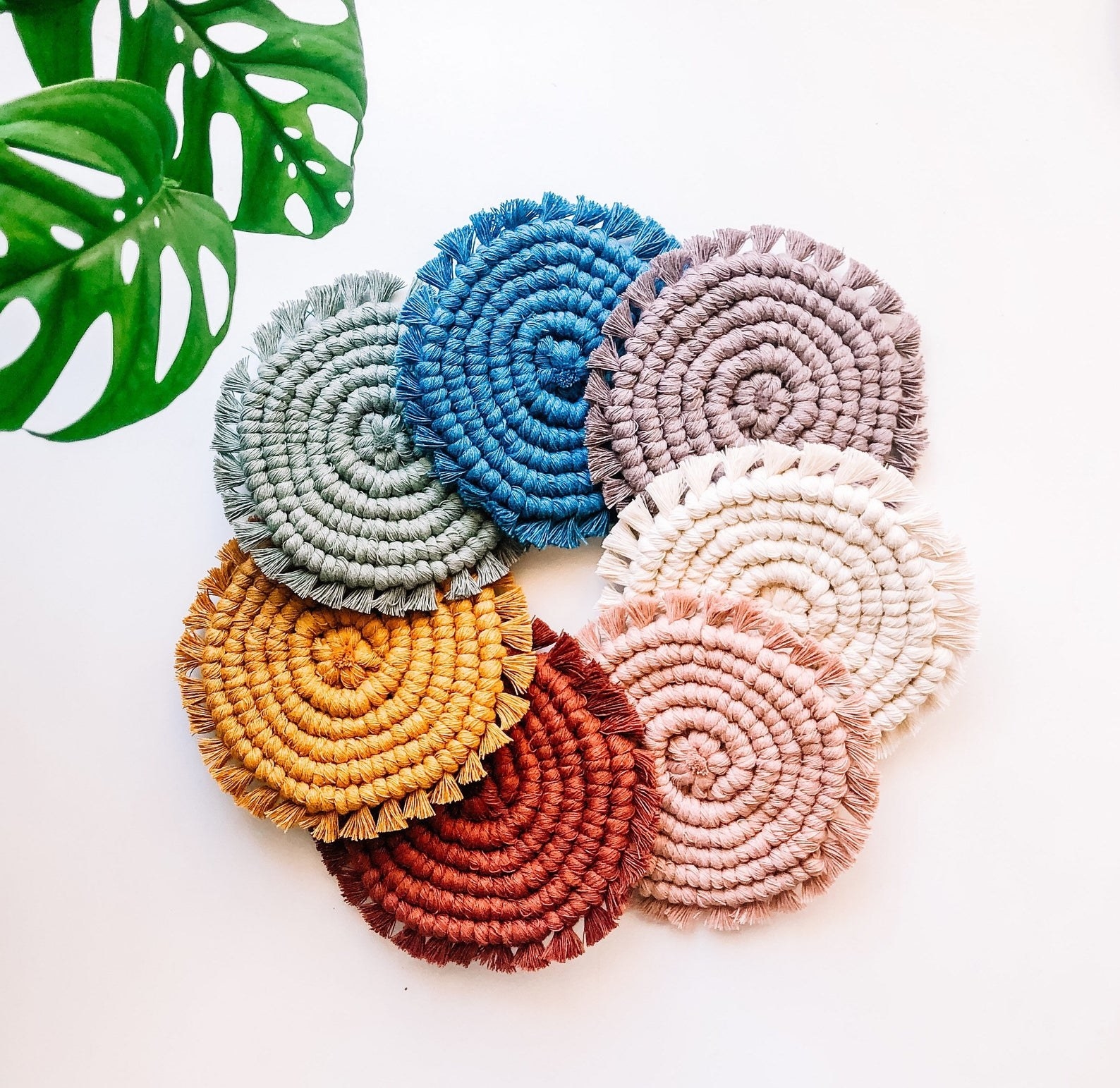 the coasters in  neutral, pink, orange, mustard, sage, blue, and lavender