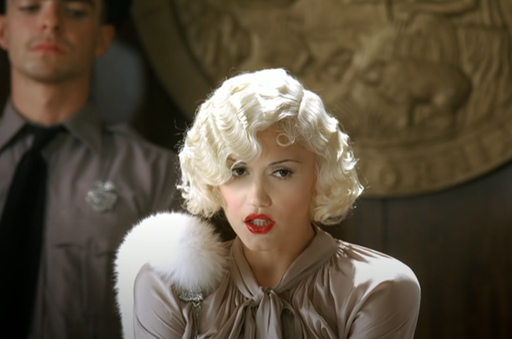 A photo of Gwen Stefani dressed as 1920s movie star taking the stand in a courtroom 