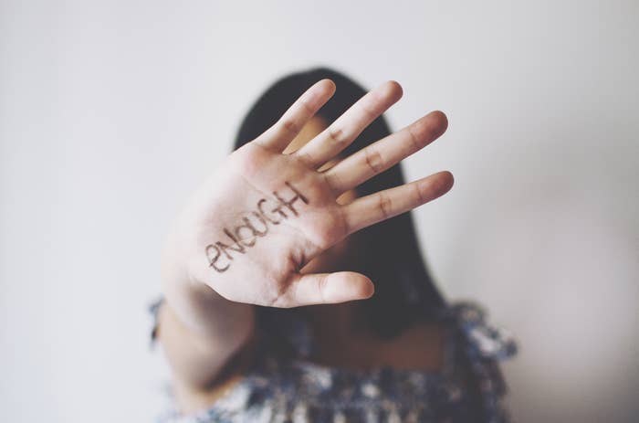 Woman whose hand says &quot;enough&quot; outstretched in front of her face