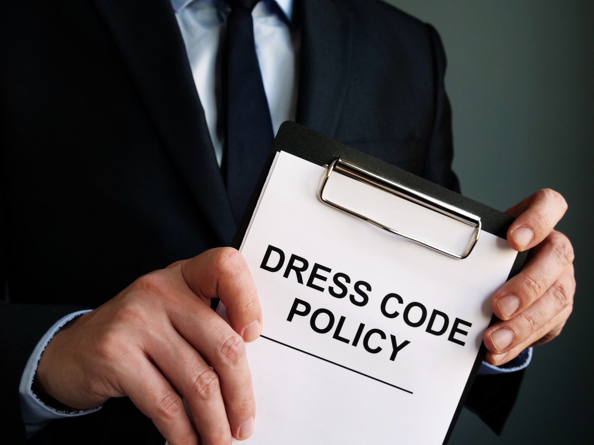 Manager holding &quot;Dress code policy&quot;