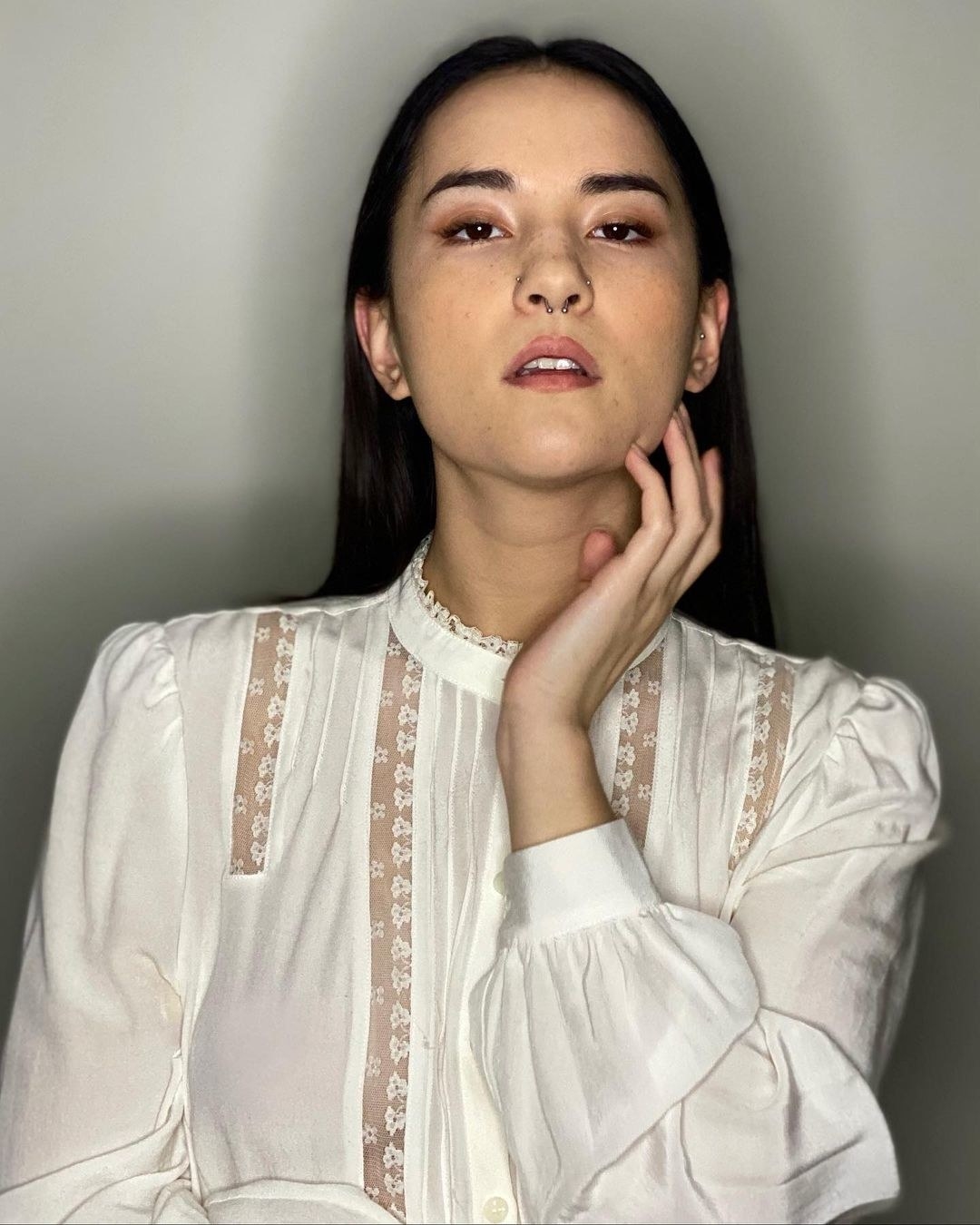 A selfie of Jessie Mei Li in a white blouse with her dark hair slicked down