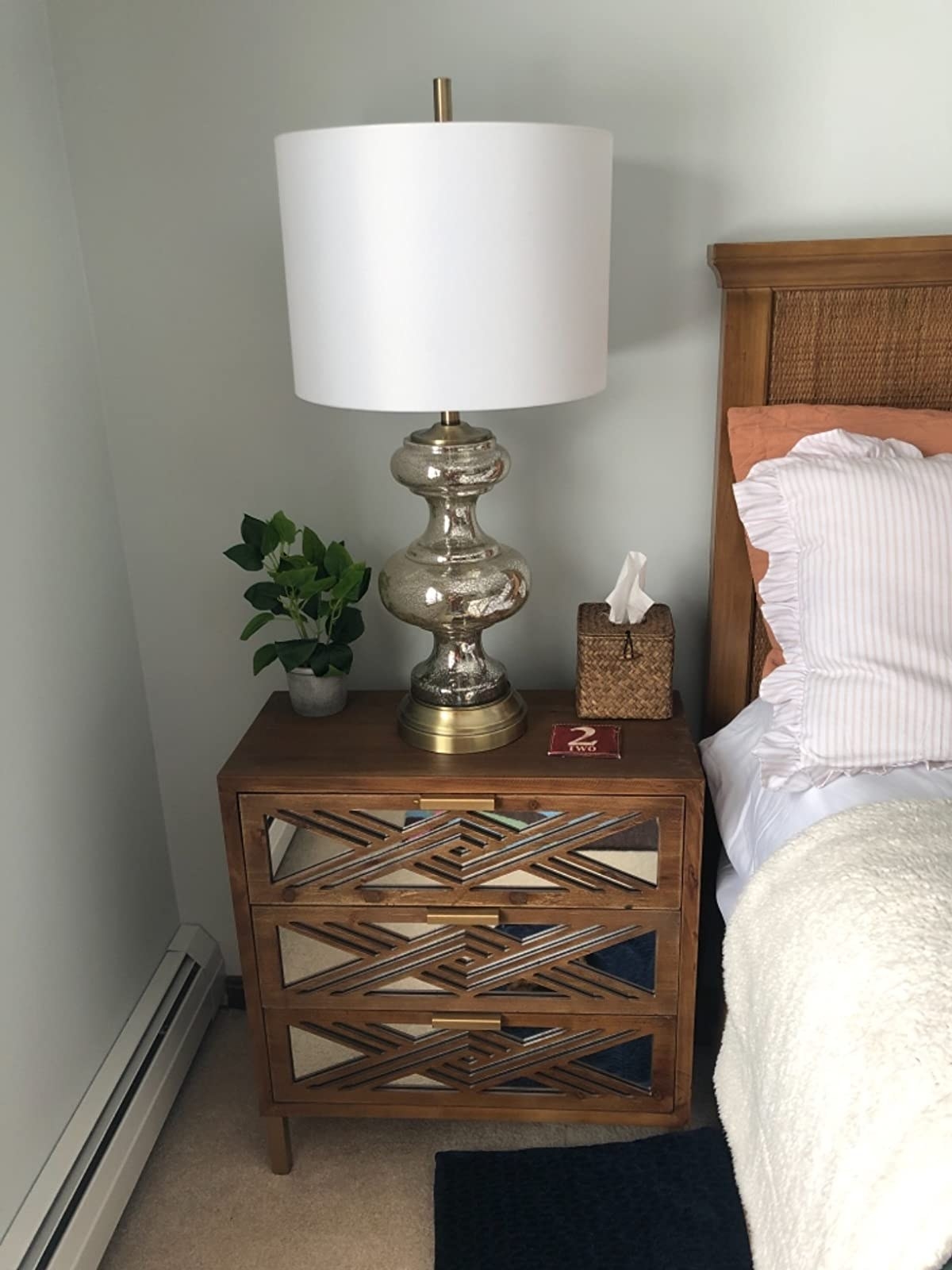 The wooden three-drawer table with mirrored drawers geometric accents