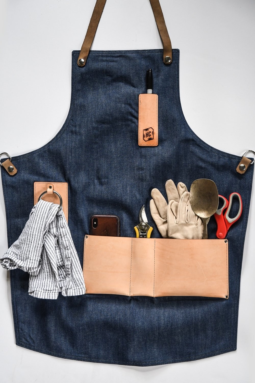 The apron is displayed with all the pockets filled with tools