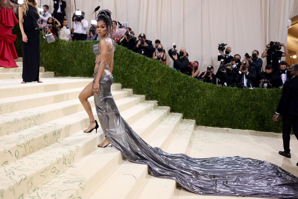 Teyana Taylor wears a gown with a criss-cross bodice that shows off her stomach and a long train