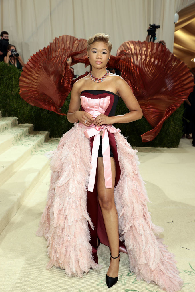 Storm Reid wears a strapless light colored gown with a feather skirt