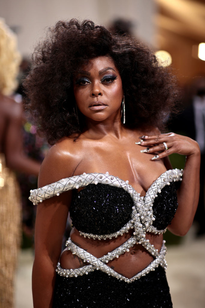 A close up of Taraji P. Henson as she shows off her dark eye makeup and afro