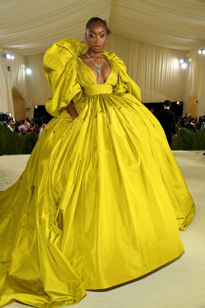 Normani wears a long sleeve brightly colored floor length gown with puffy sleeves