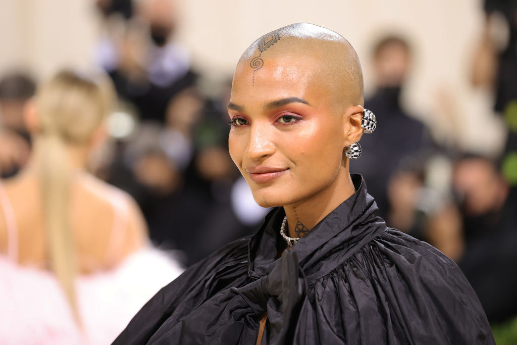 A close up of Indya Moore as they show off their head tattoo