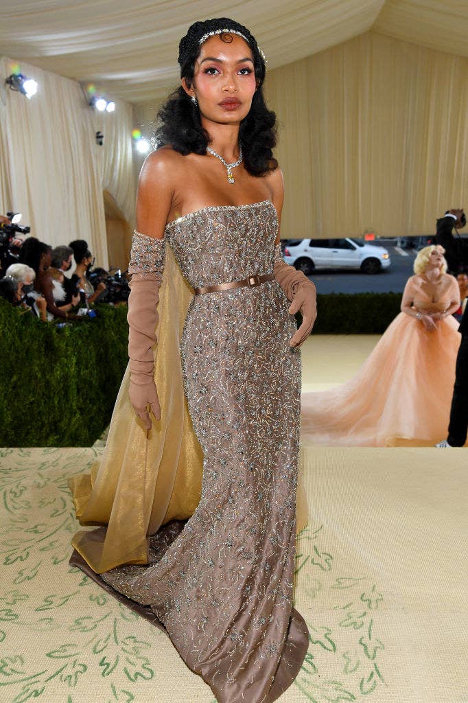Yara Shahidi wears a floor length strapless gown with diamonds patterned sewn into it and matching elbow length gloves