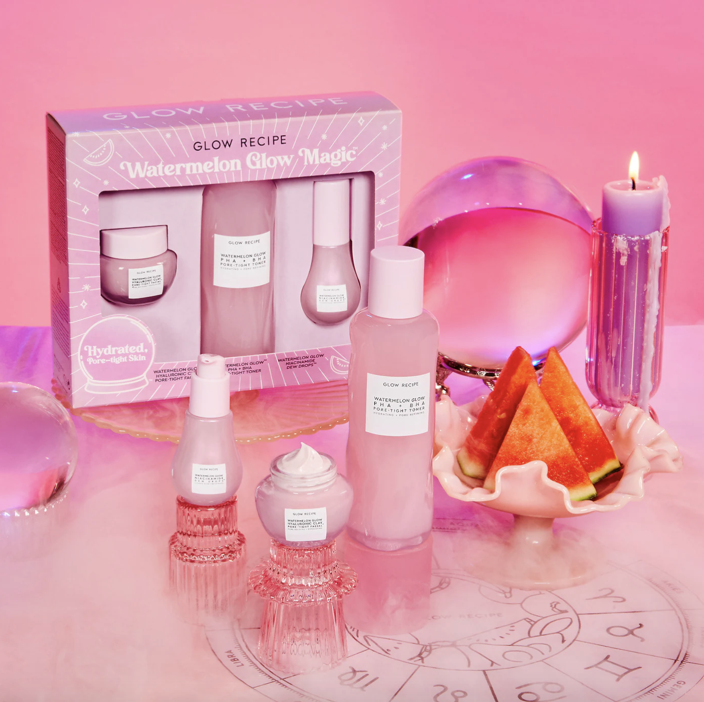 the packaged gift set of watermelon glow magic glow recipe bottles and the three containers of product in front of it with a crystal ball next to them