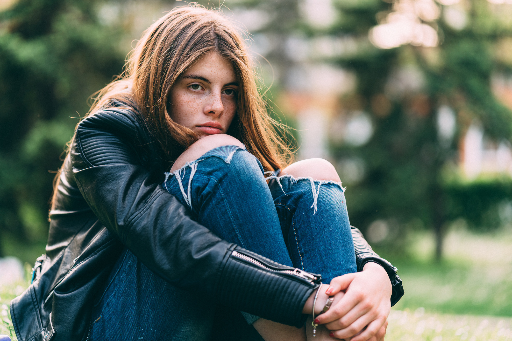 sad teen girl sitting with her head on her knees