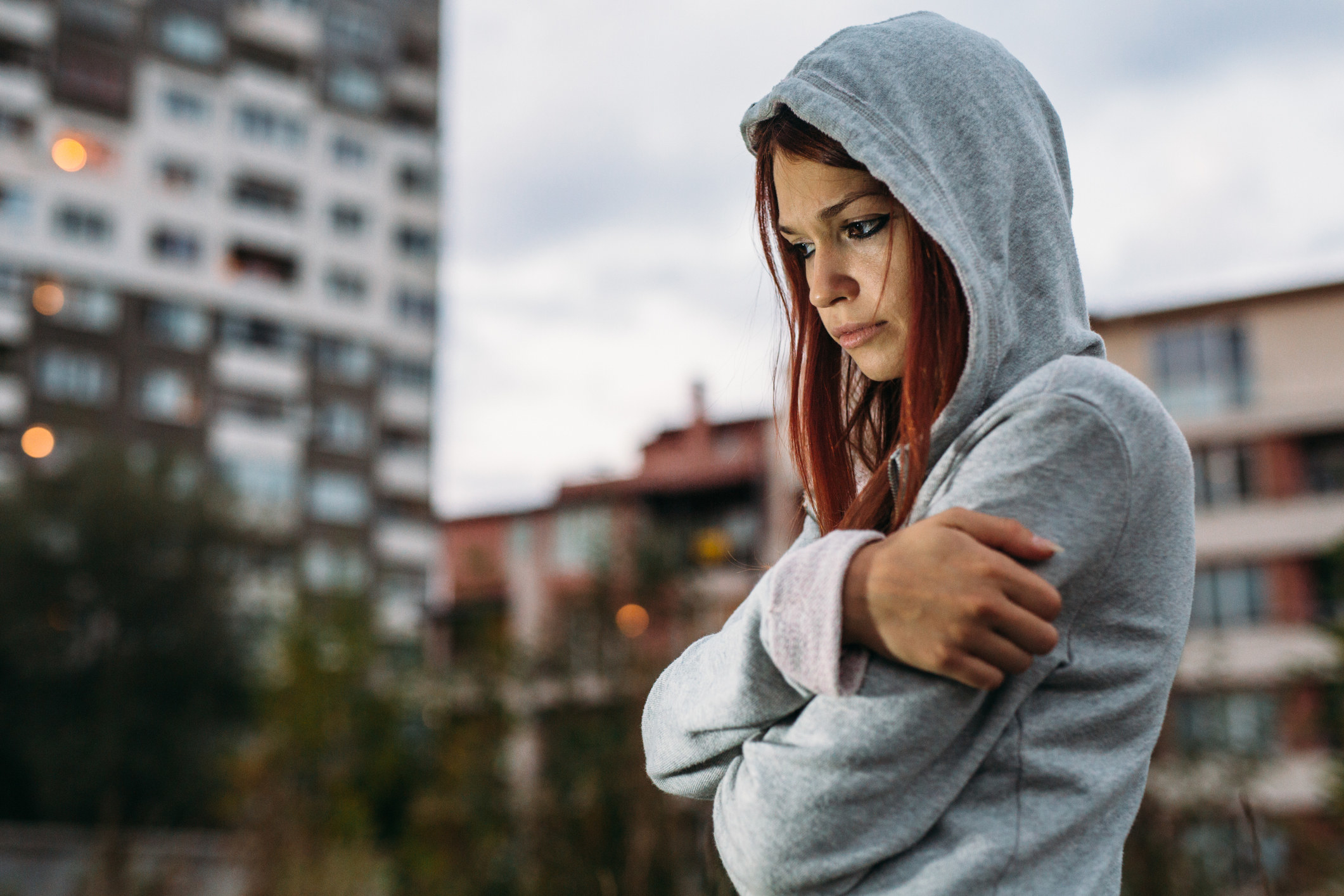 young girl in a sweatshirt covering her chest