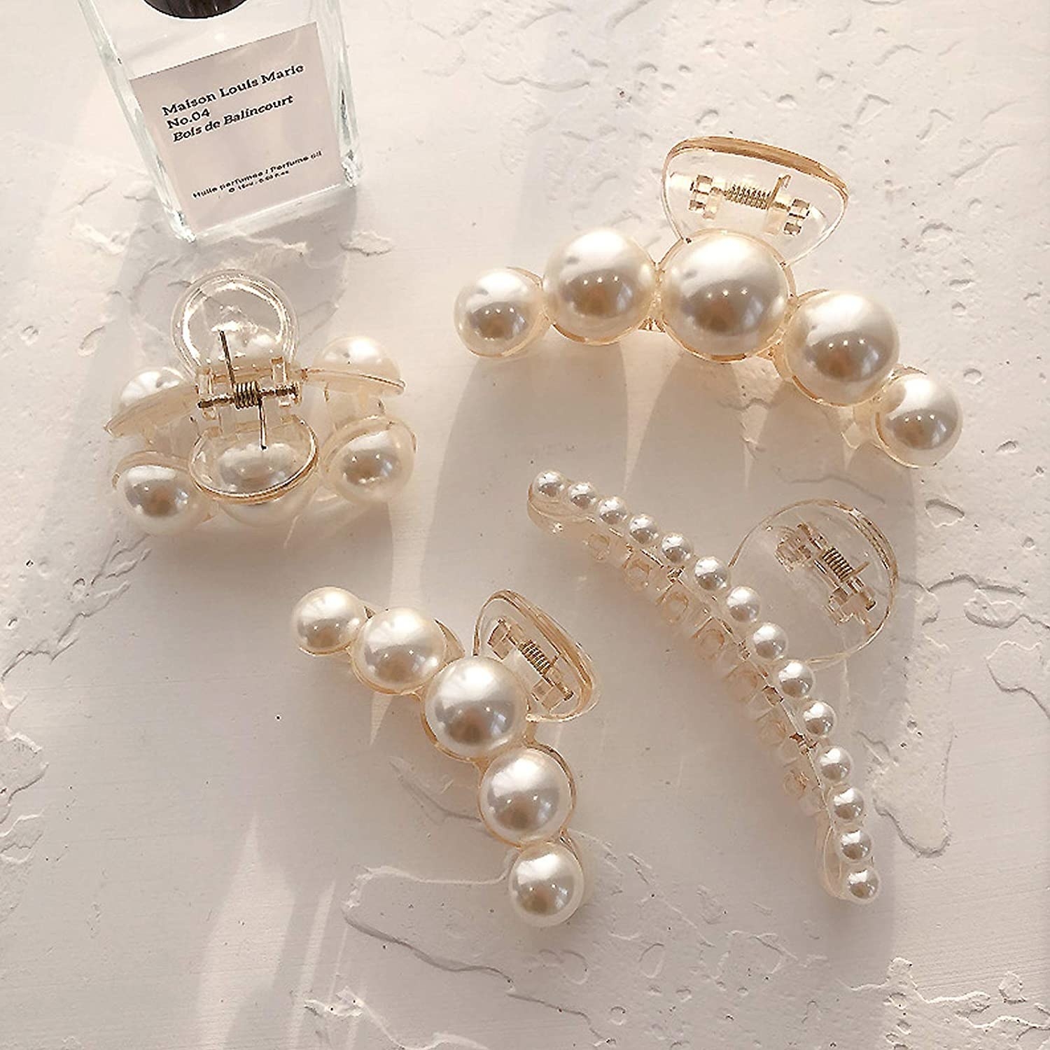 Four pearl claw clips of varying sizes