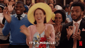 GIF of Ellie Kemper in Unbreakable Kimmy Schmidt waving her hands, caption &quot;It&#x27;s a miracle&quot;