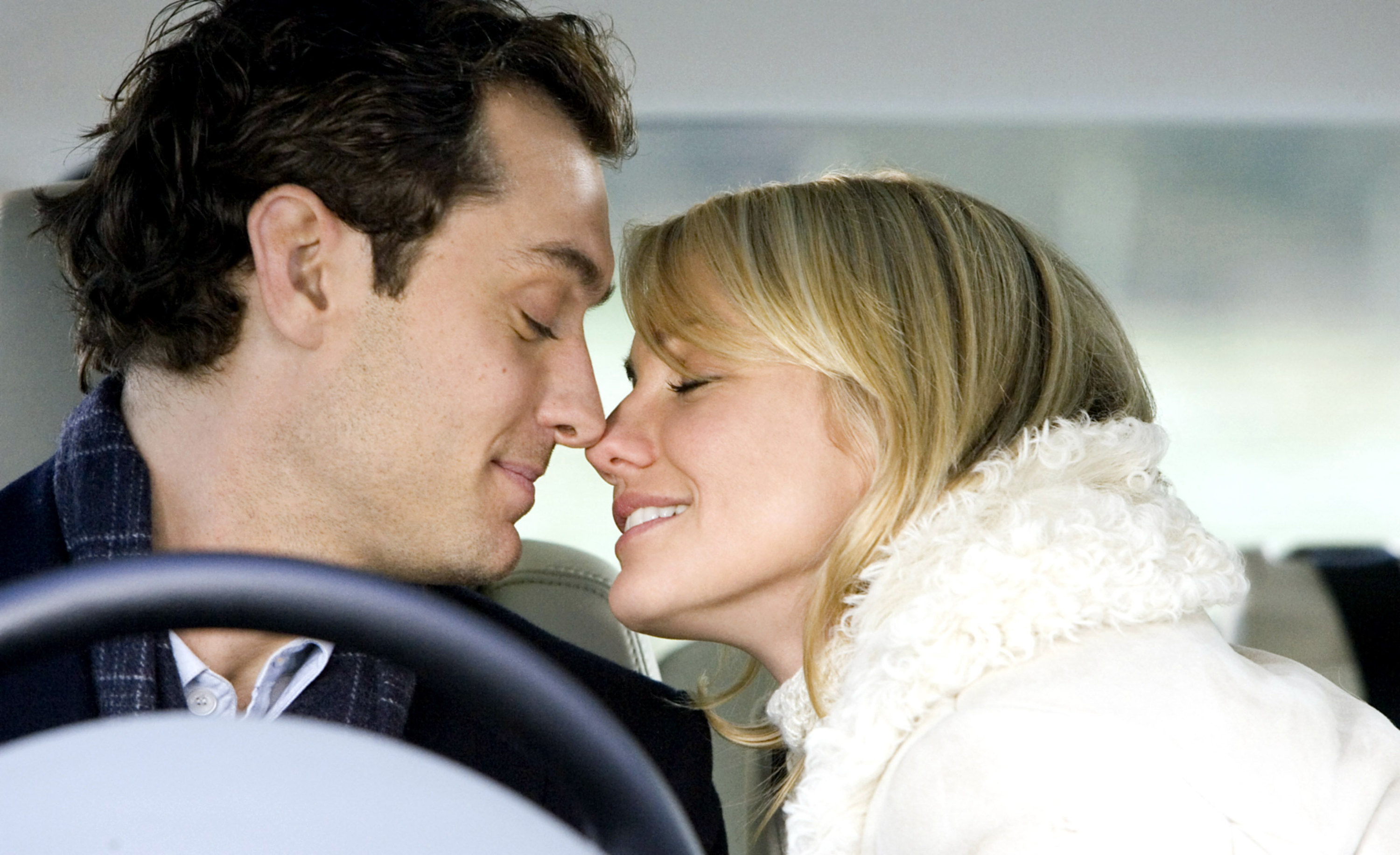 A man and woman kiss in a car