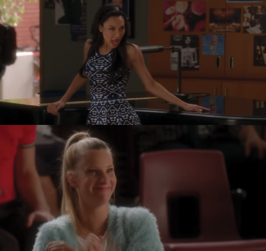 Santana Lopez wears a sleeveless patterned dress as she leans against a piano and Brittany Pierce wears a brightly colored fuzzy jacket as she smiles