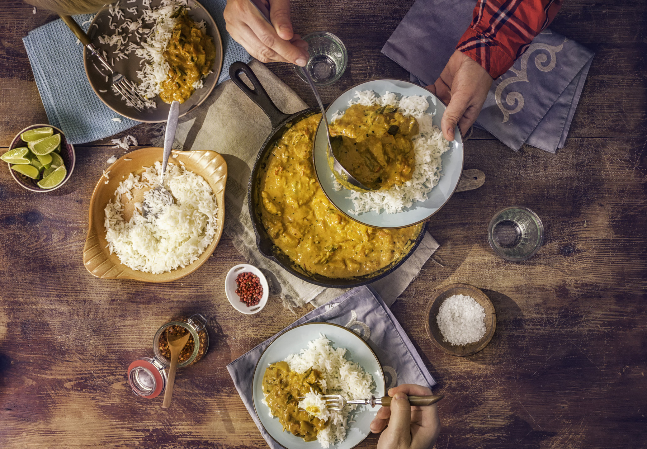 Family eating homemade chicken curry dish with basmati rice.