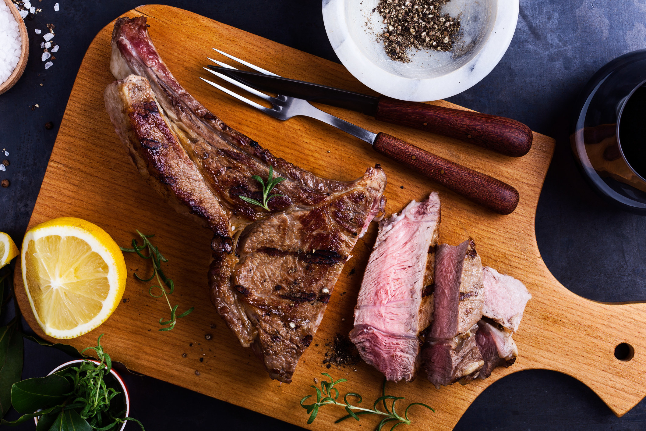 Barbecue bone-in ribeye steak on cutting board ready to eat.