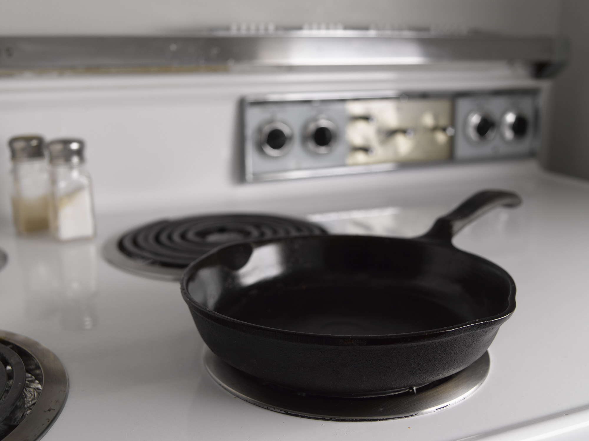 A clean cast iron skillet on a stove top.