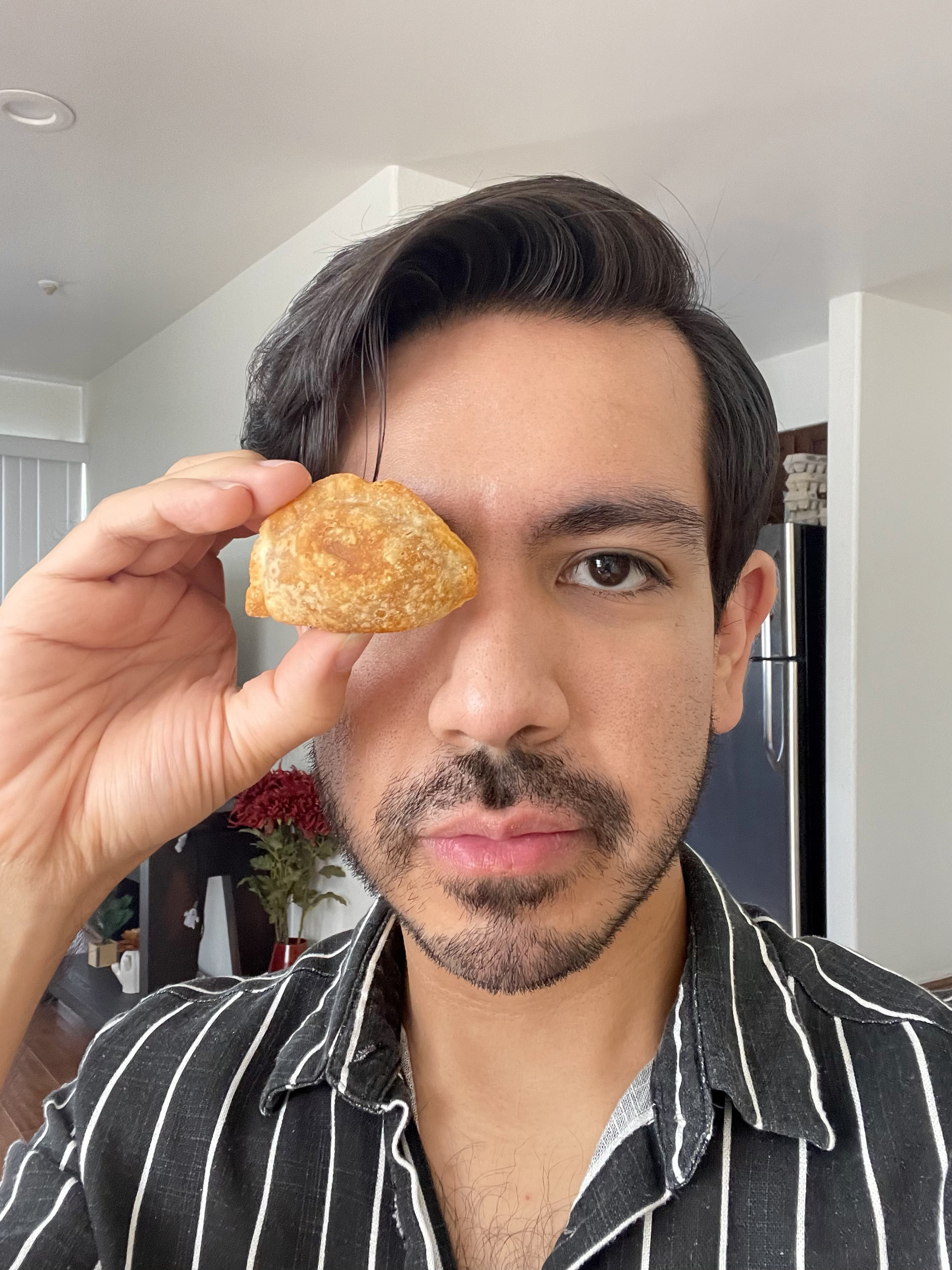 The author holding an empanada up to his eye