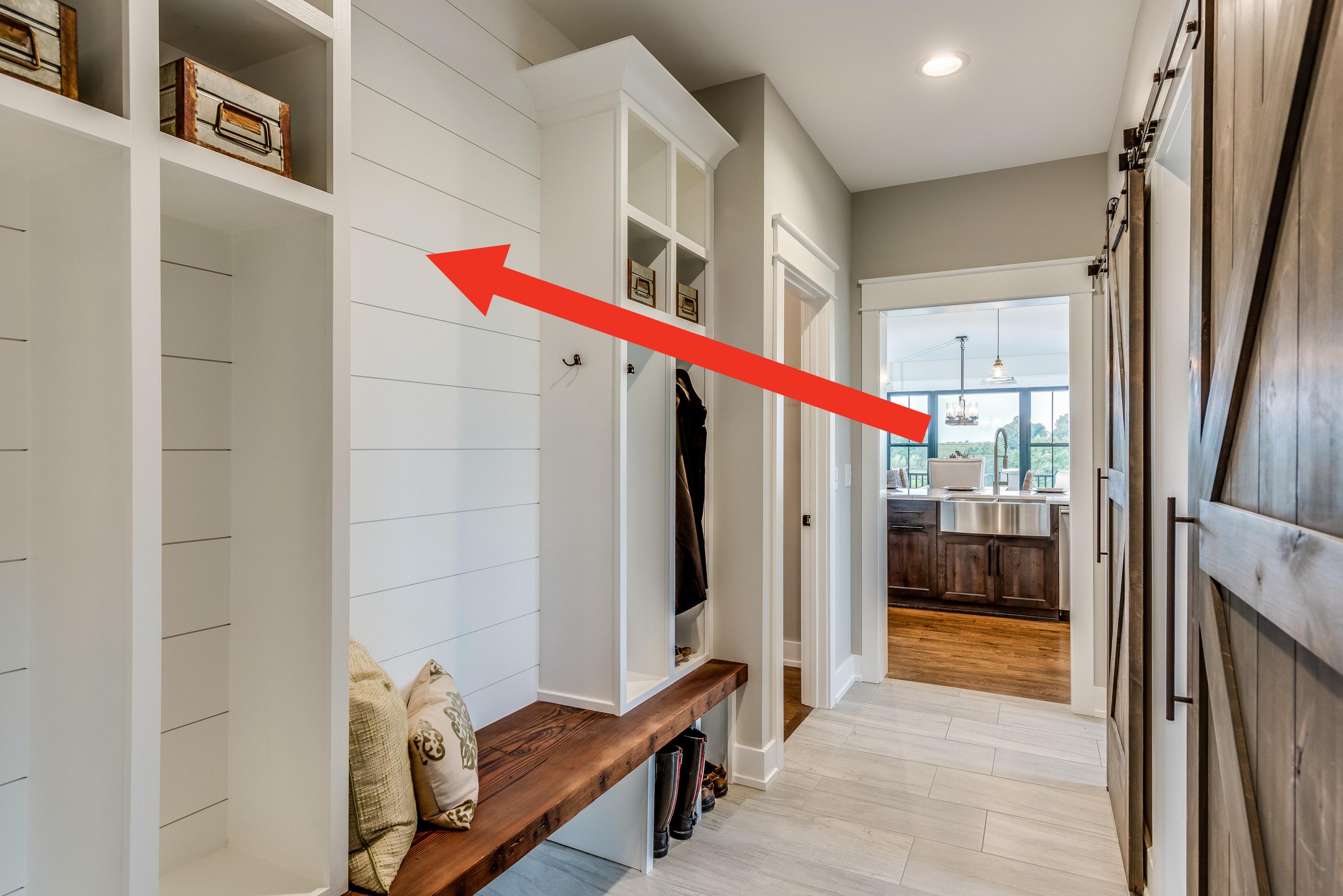 Arrow pointing to white shiplap walls in a hallway