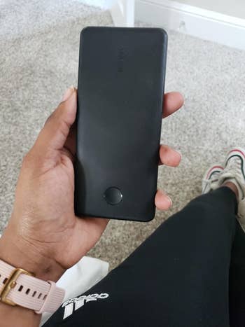 Reviewer holding black rectangular power bank