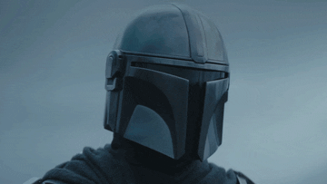 The Mandalorian stands below an overcast sky