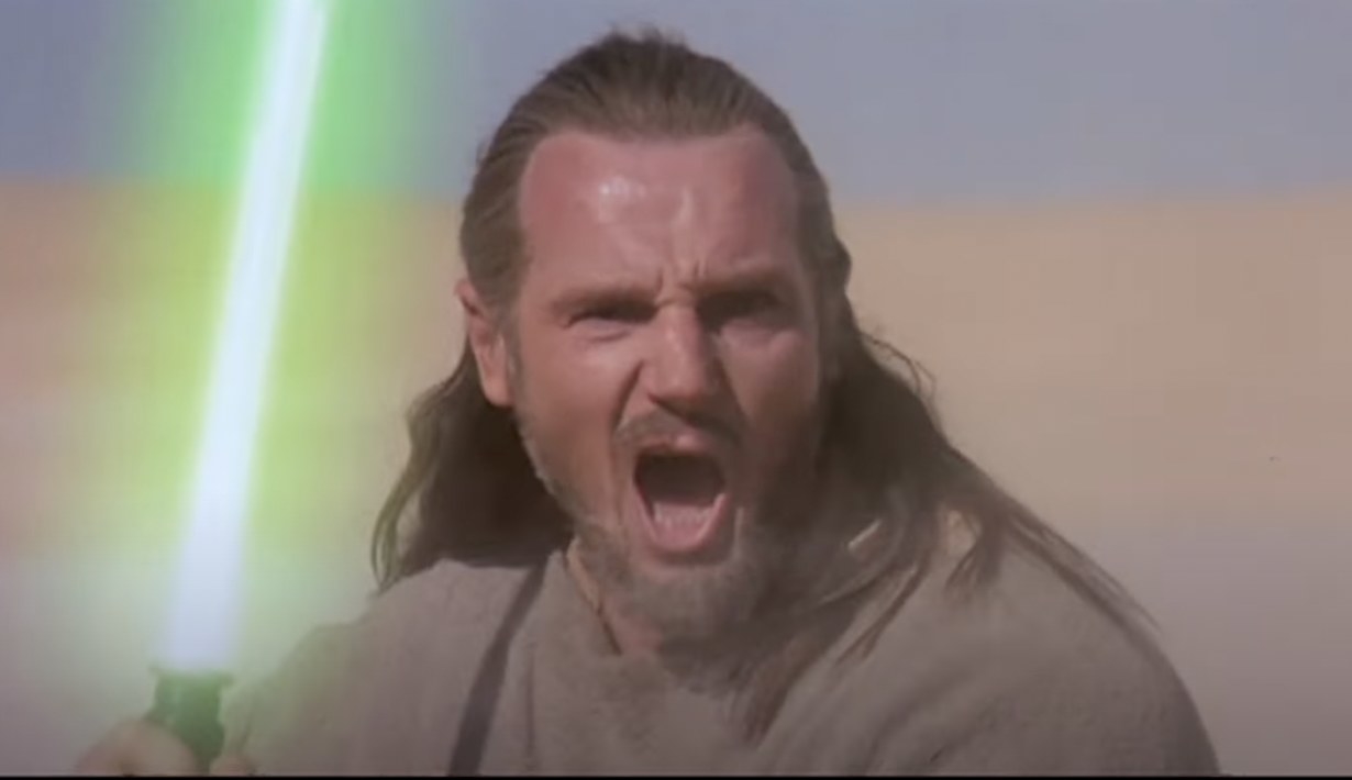 Liam Neeson as Qui-Gon Jinn from &quot;Star Wars: Episode I - The Phantom Menace&quot; holding a lightsaber