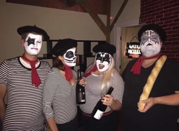 four people wearing striped shirts holding wine and bread