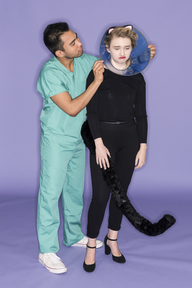 A man dressed in scrubs and a woman wearing a cat costume and a cone around her head
