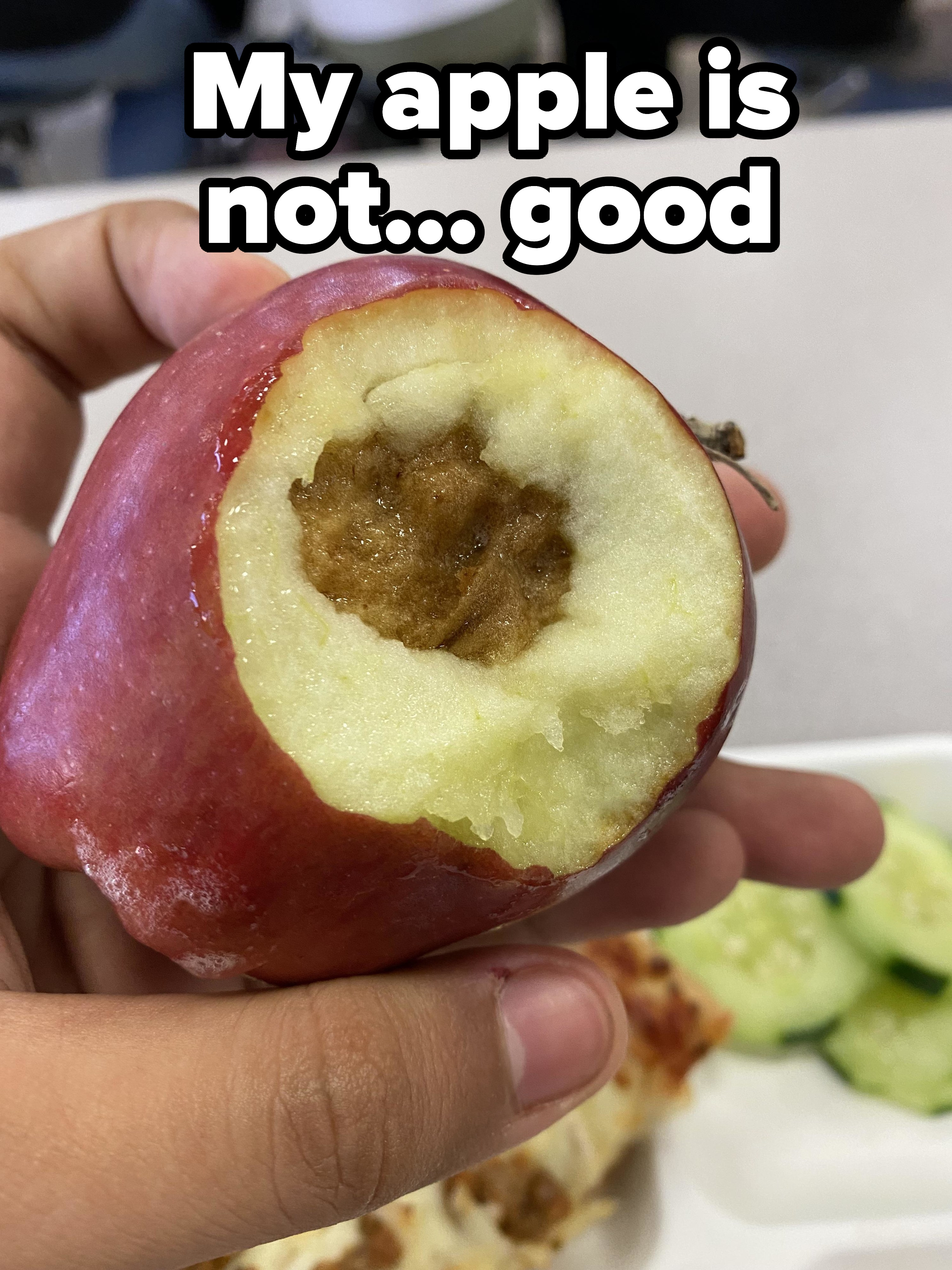 A person holds an apple with a large, rotten brown spot and bite marks. Text overlay reads &quot;My apple is not... good.&quot;