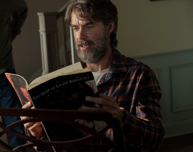 Murray Bartlett as Frank, reads a book