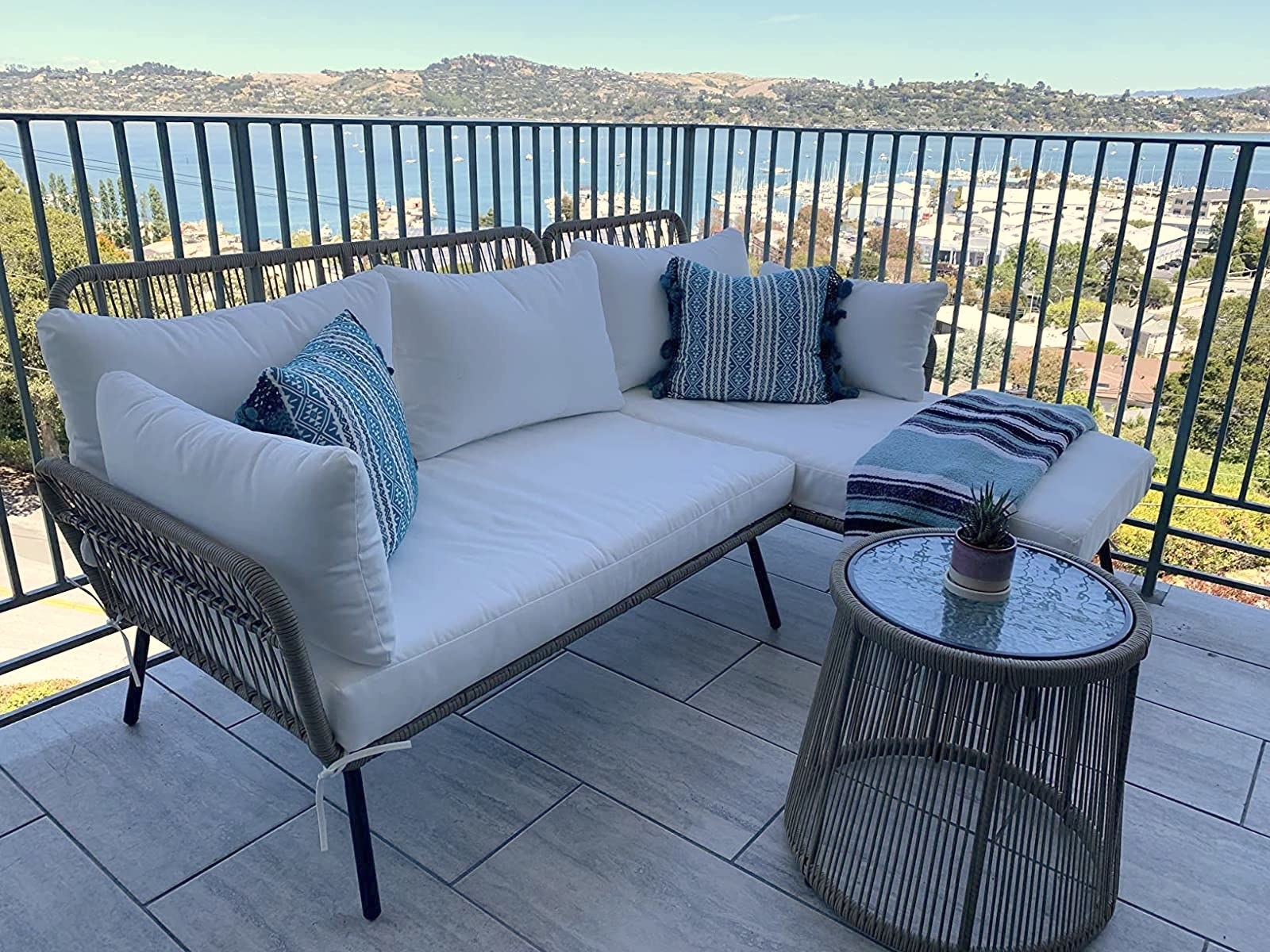 A sofa chase sectional and small table are shown on a balcony