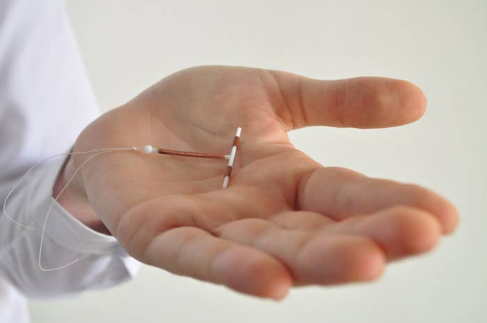 A close-up of someone&#x27;s hand holding an IUD