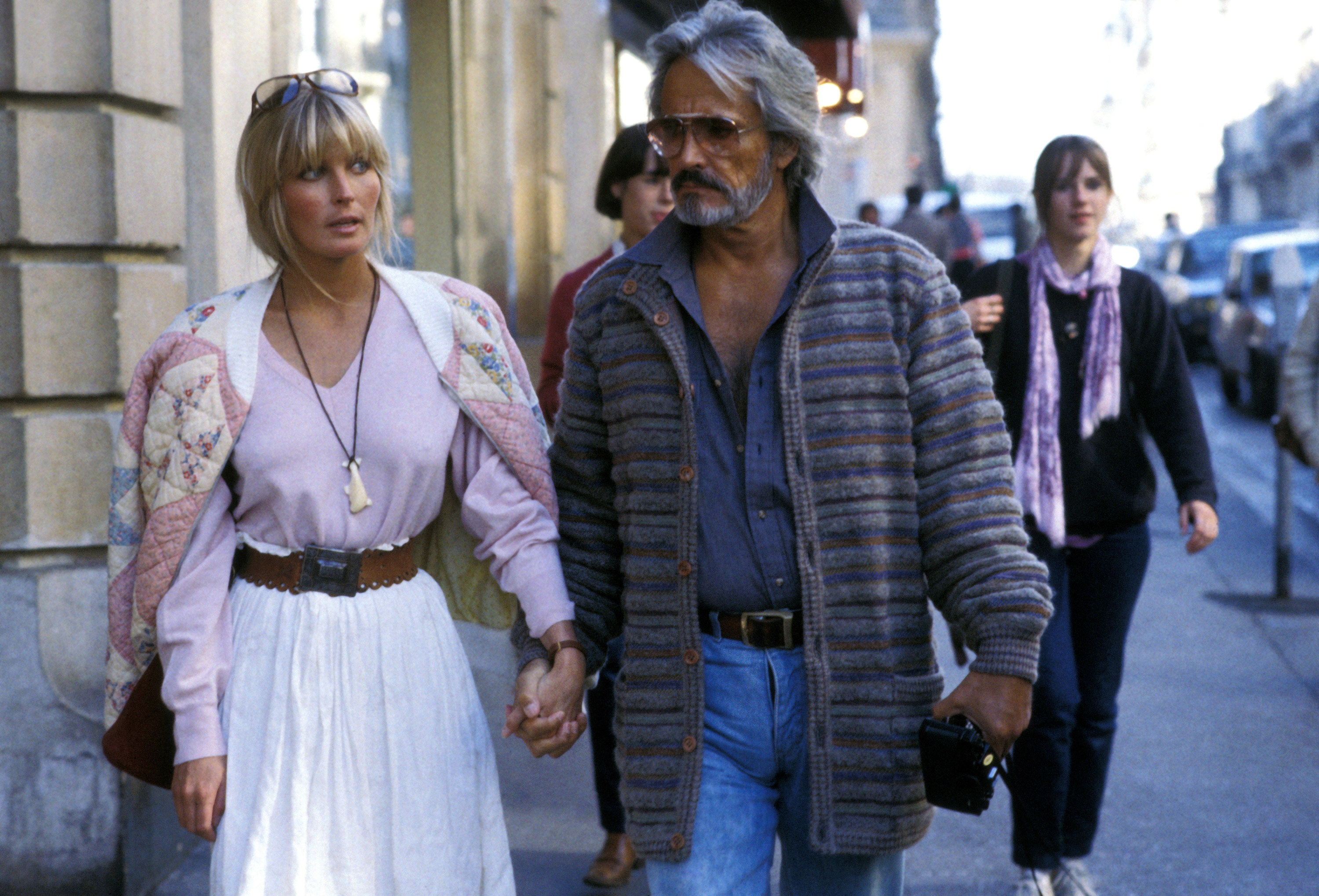 the two holding hands on the street