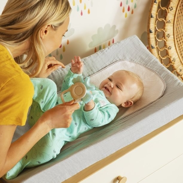 Parent plays with baby on changing table