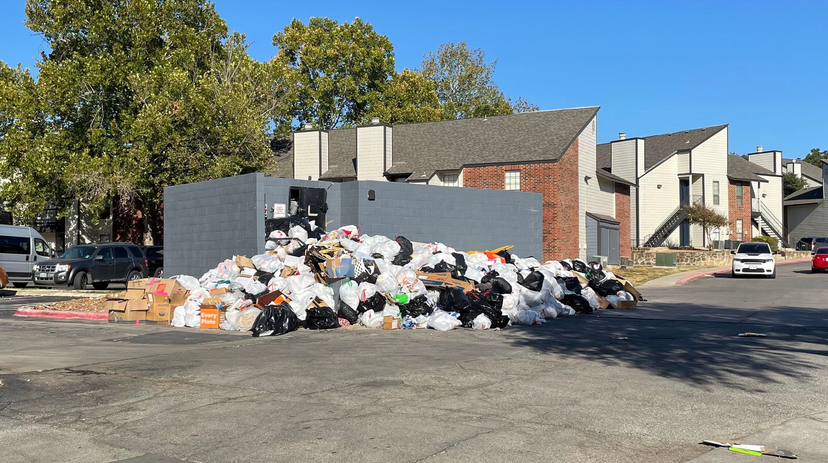 large pile of trash where a dumpster should be