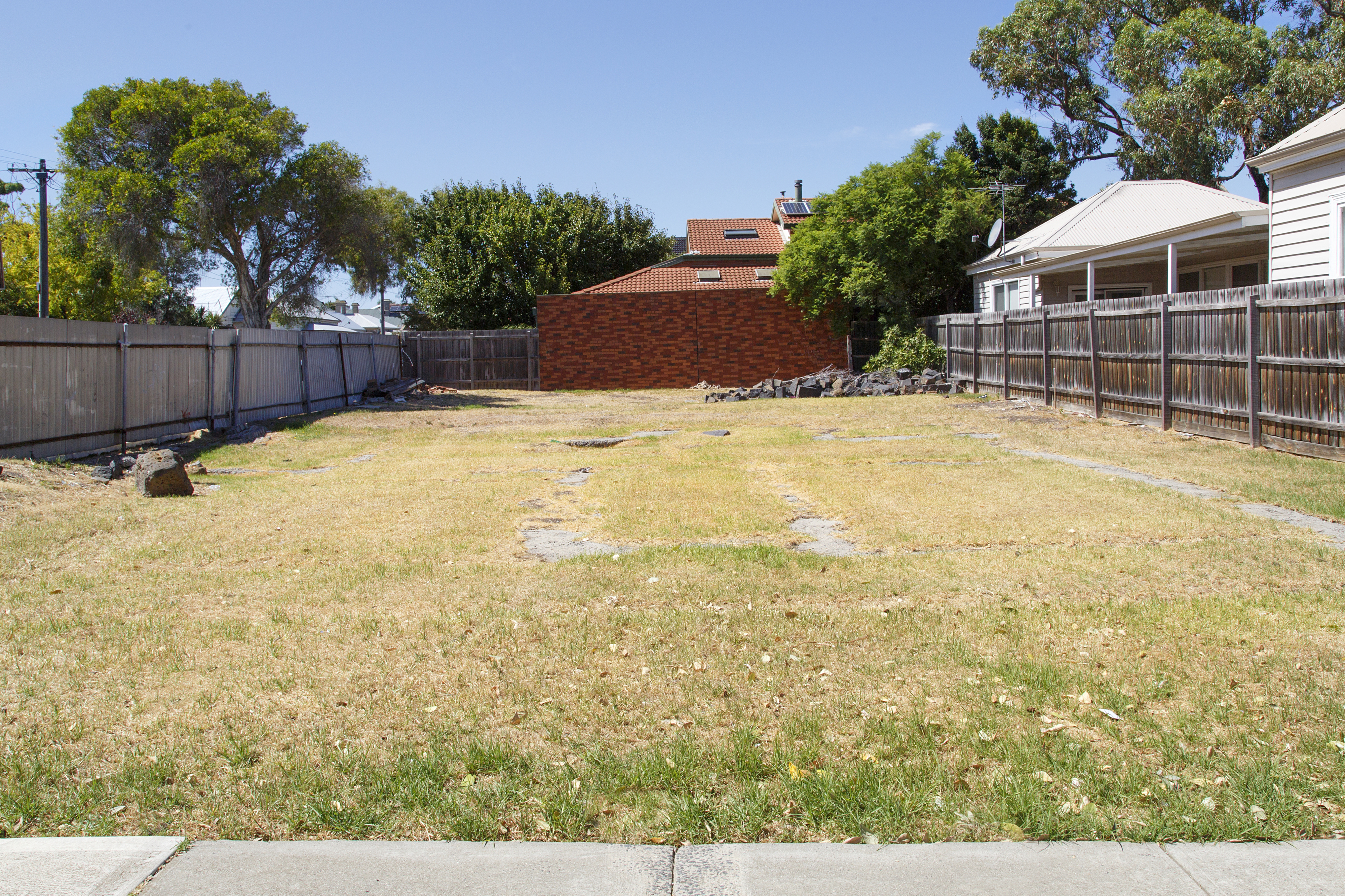 empty lot on a street, covered in grass