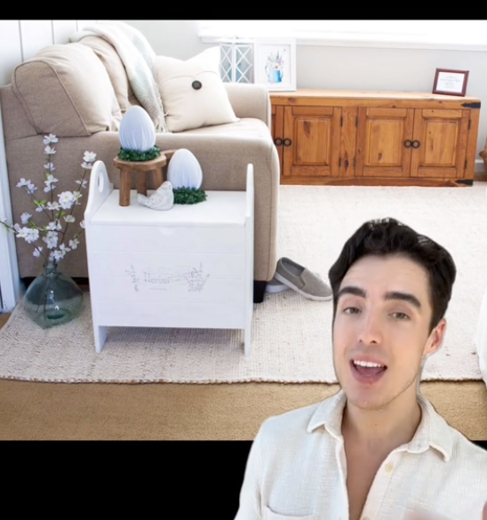 Tommy in front of a carpet with a white rug placed on top of it in a living room