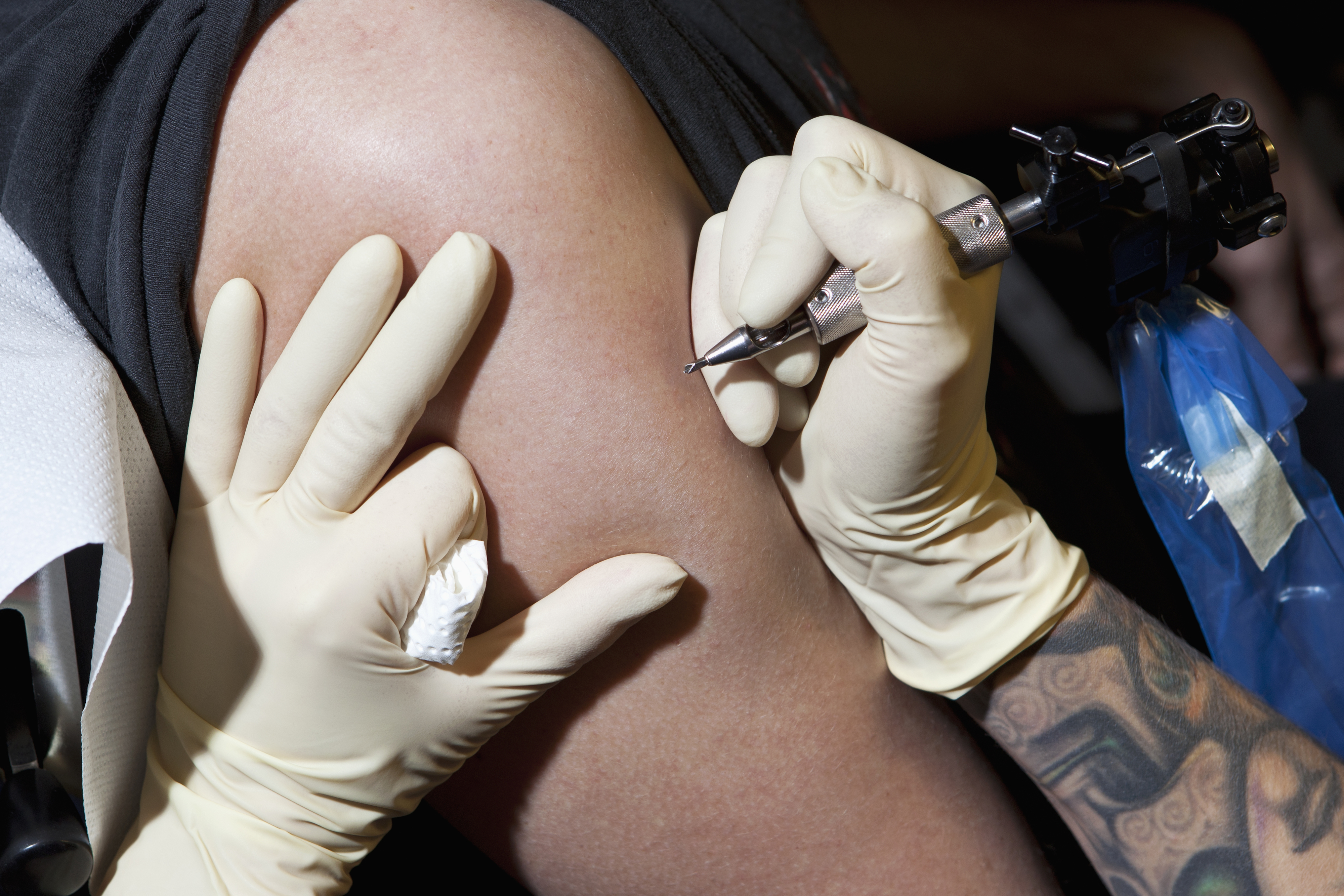 A tattoo artist about to tattoo a person&#x27;s arm