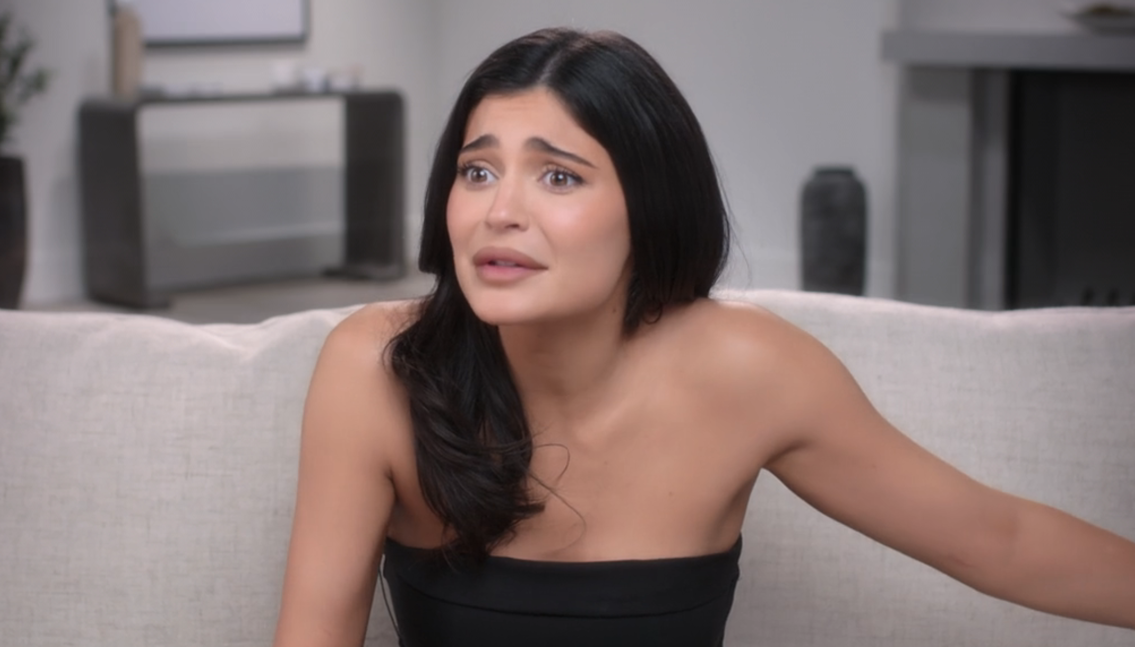 Close-up of Kylie sitting and wearing a strapless top