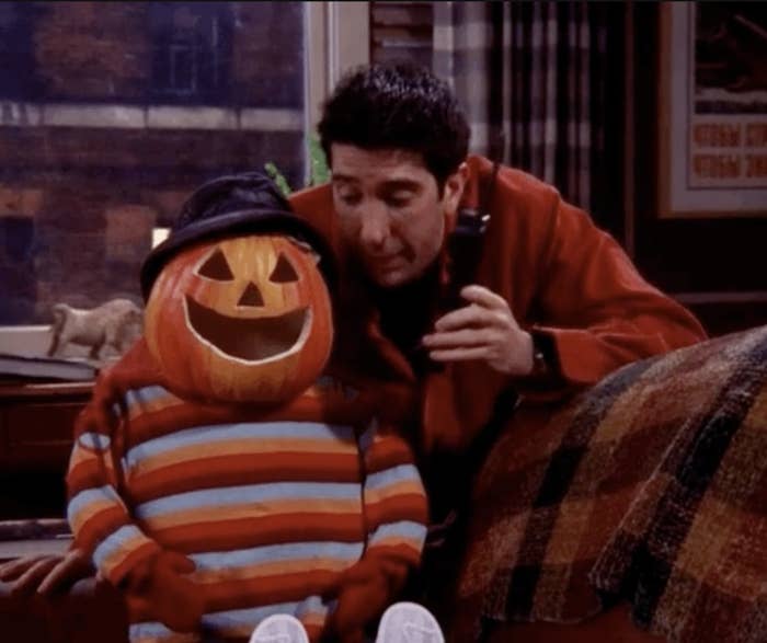 ross geller sitting next to a pumpkin head