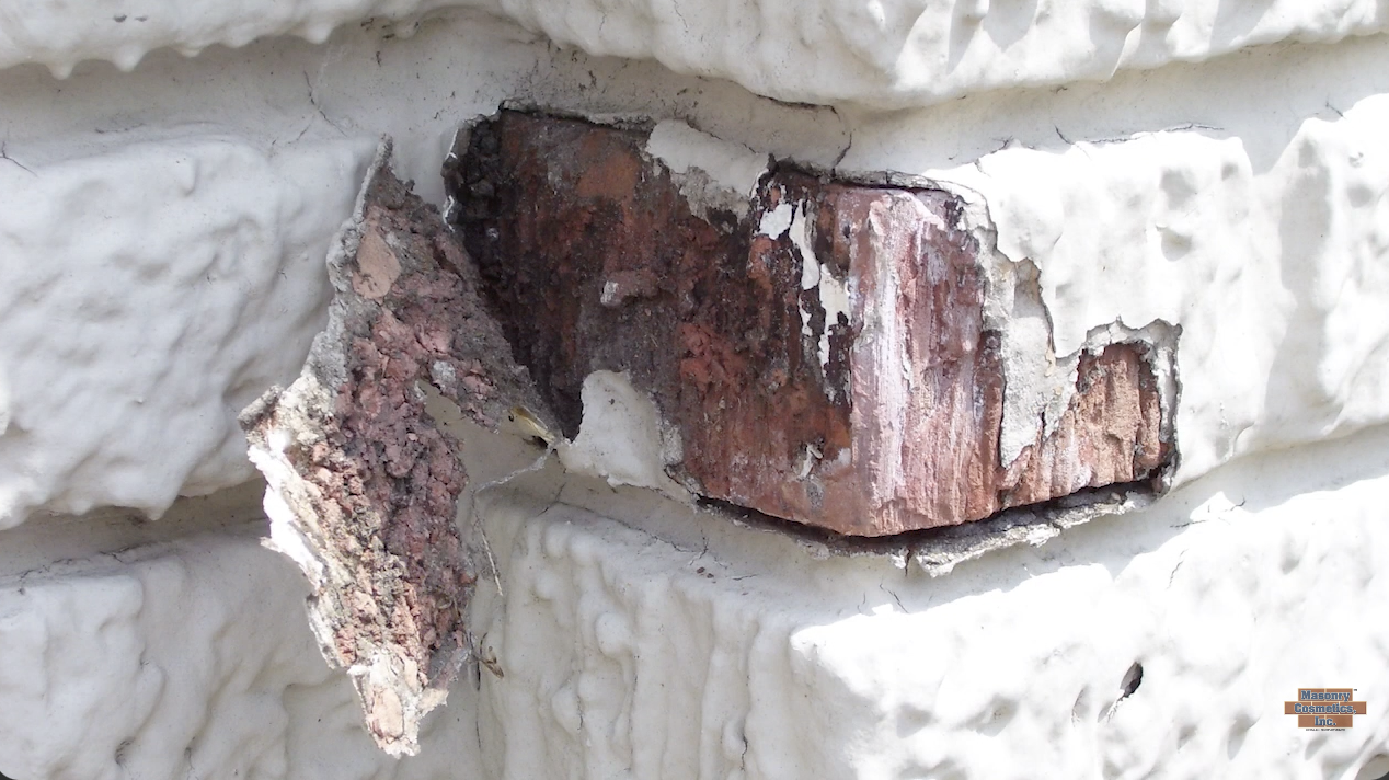 paint peeling off of a brick to expose damage