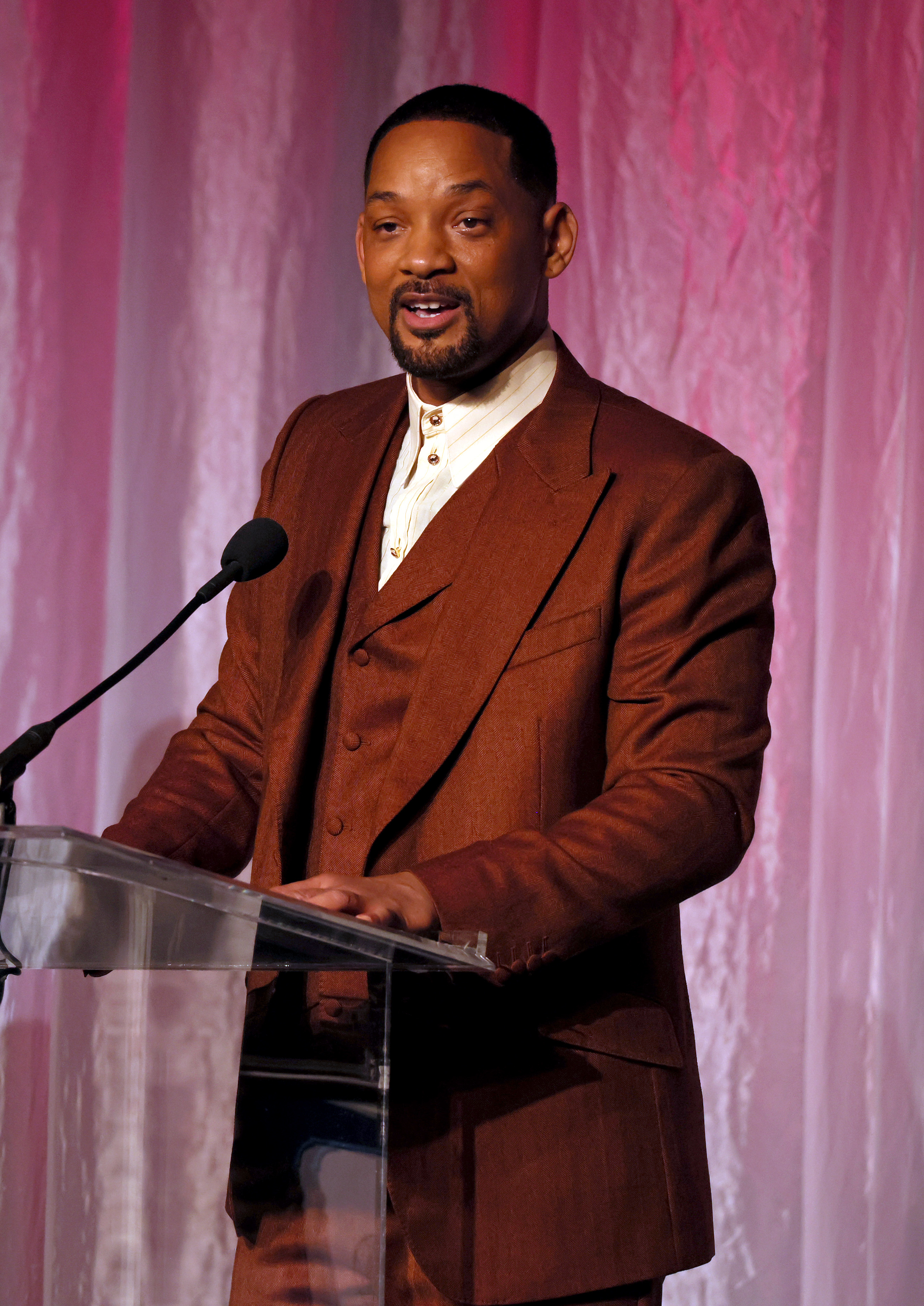 he&#x27;s in a suit speaking at a podium