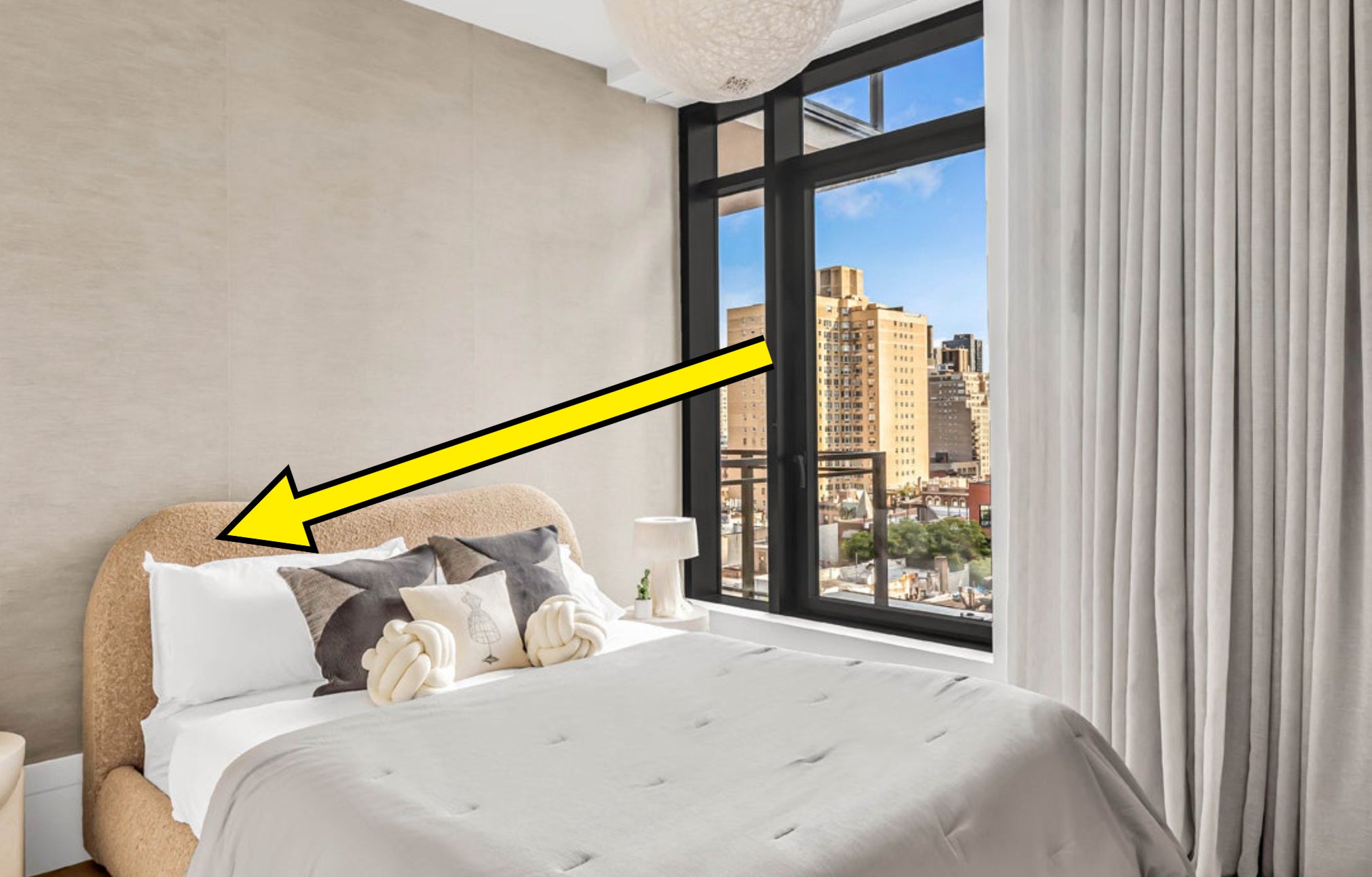 arrow pointing to a bouclé fabric bed in an apartment building