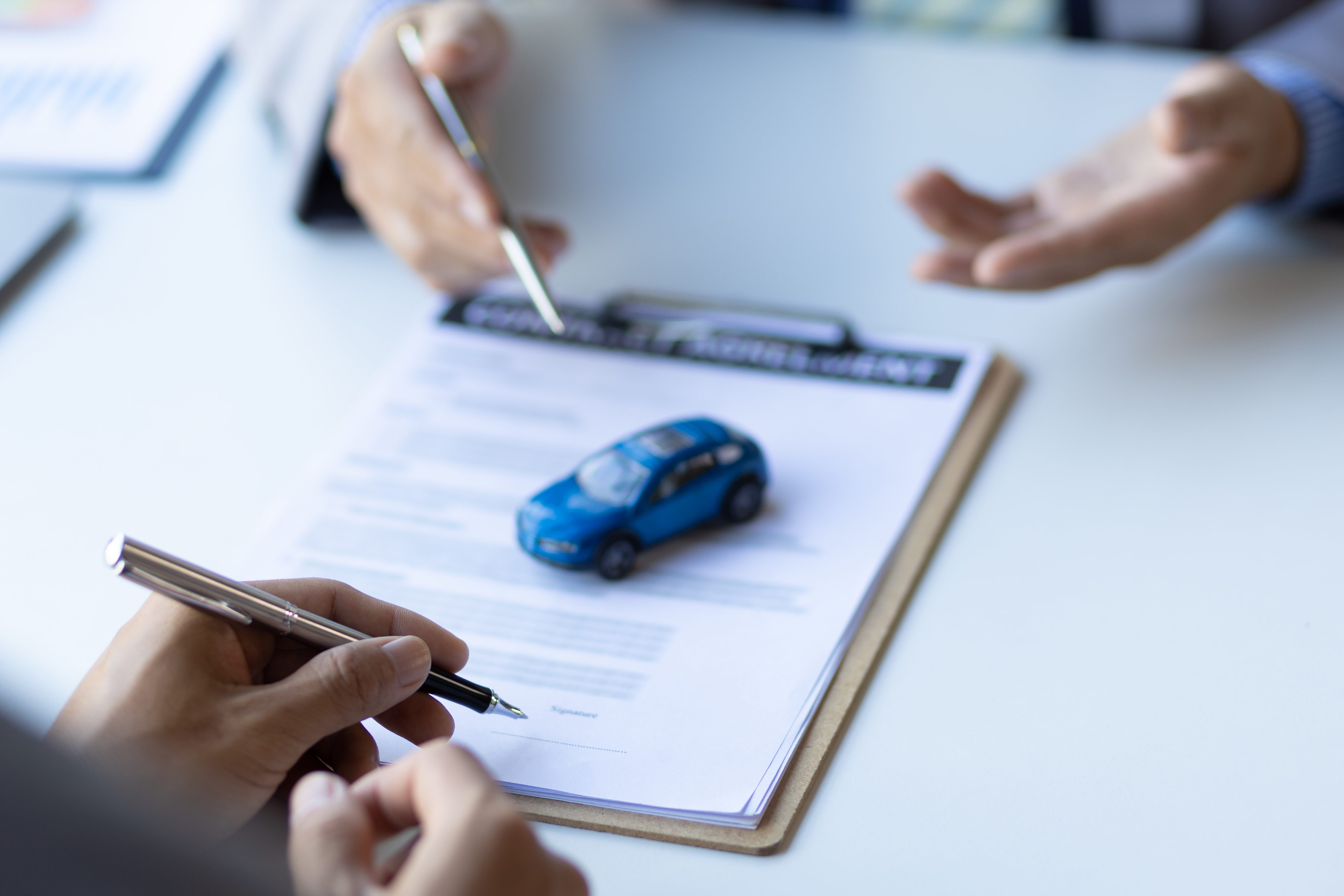 Person signing paperwork for a car