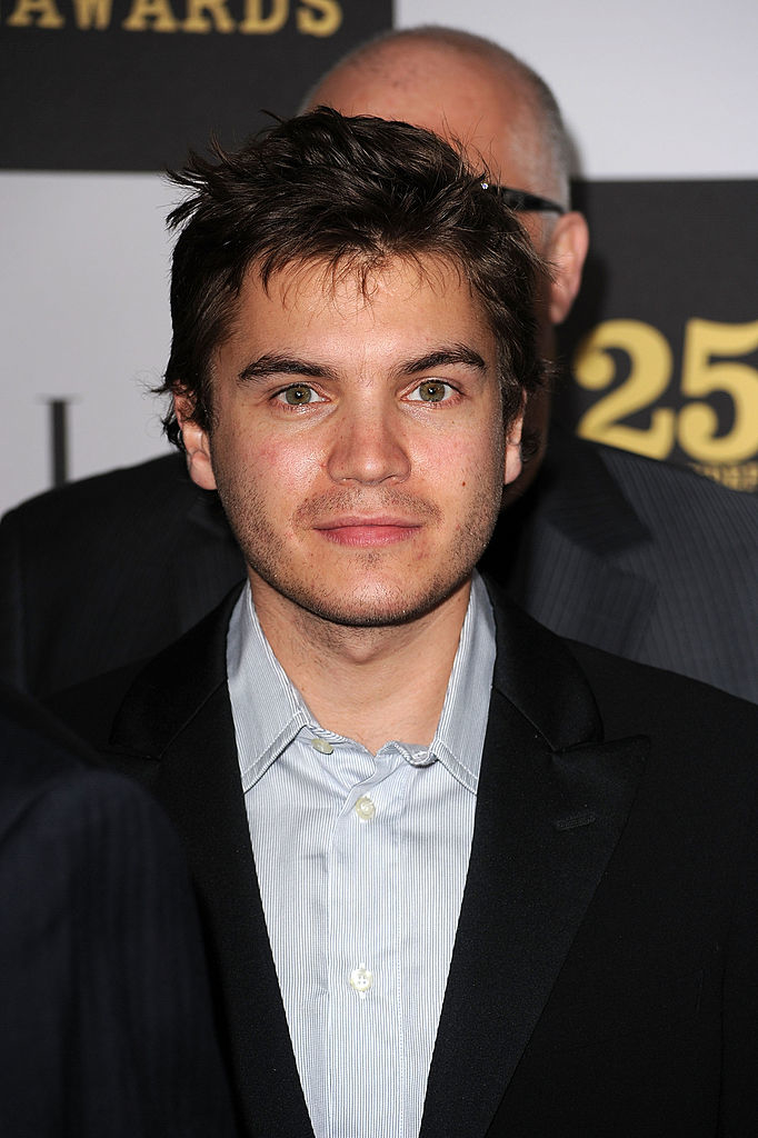 A person with short, tousled hair wearing a light-colored shirt and a dark blazer at an award event