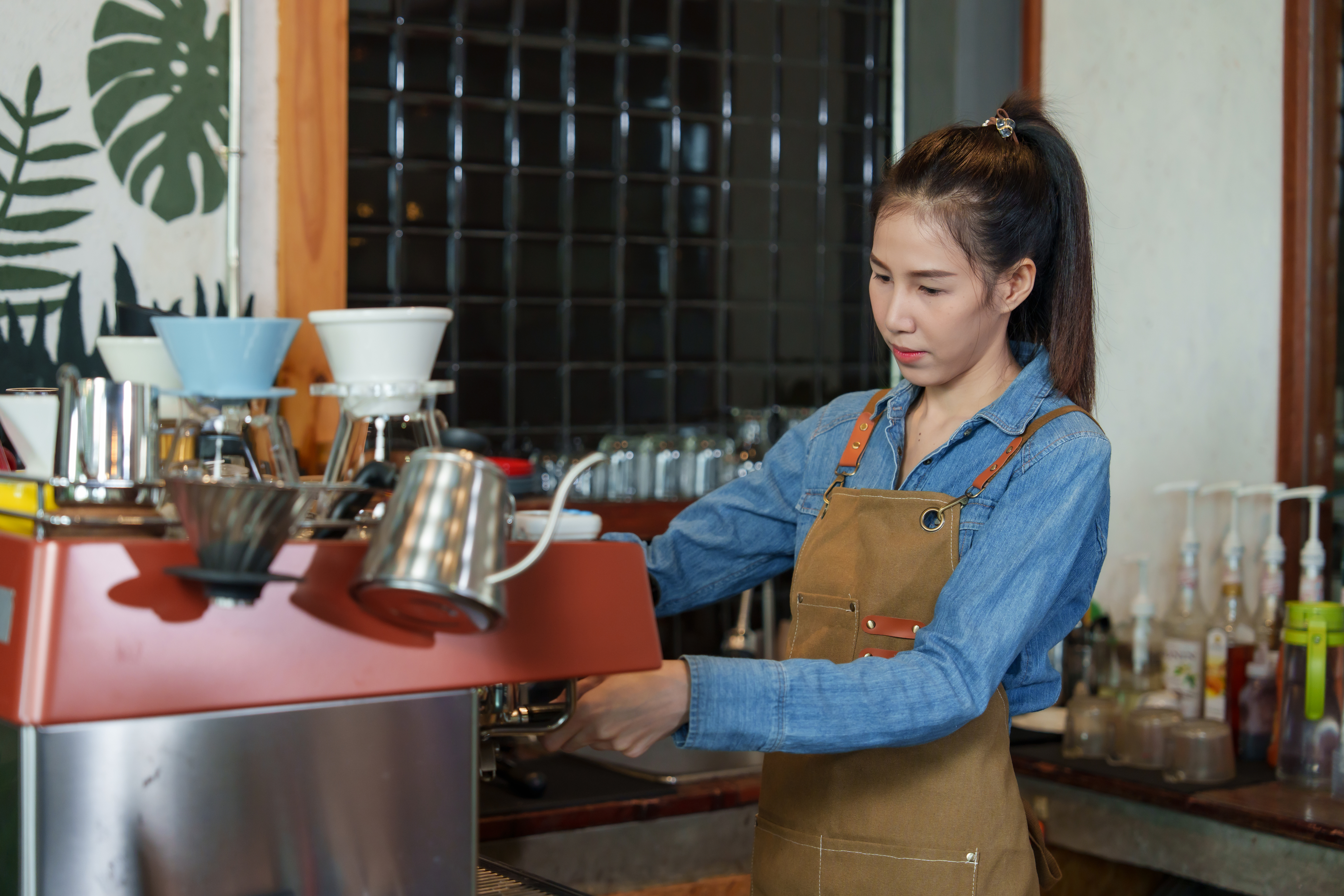 a girl making coffee at a coffee shop